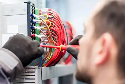 Electrician inspecting electrical wiring for code compliance